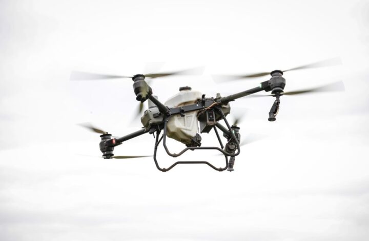 A drone capturing high-resolution aerial images for land surveying tasks over a vast landscape.
